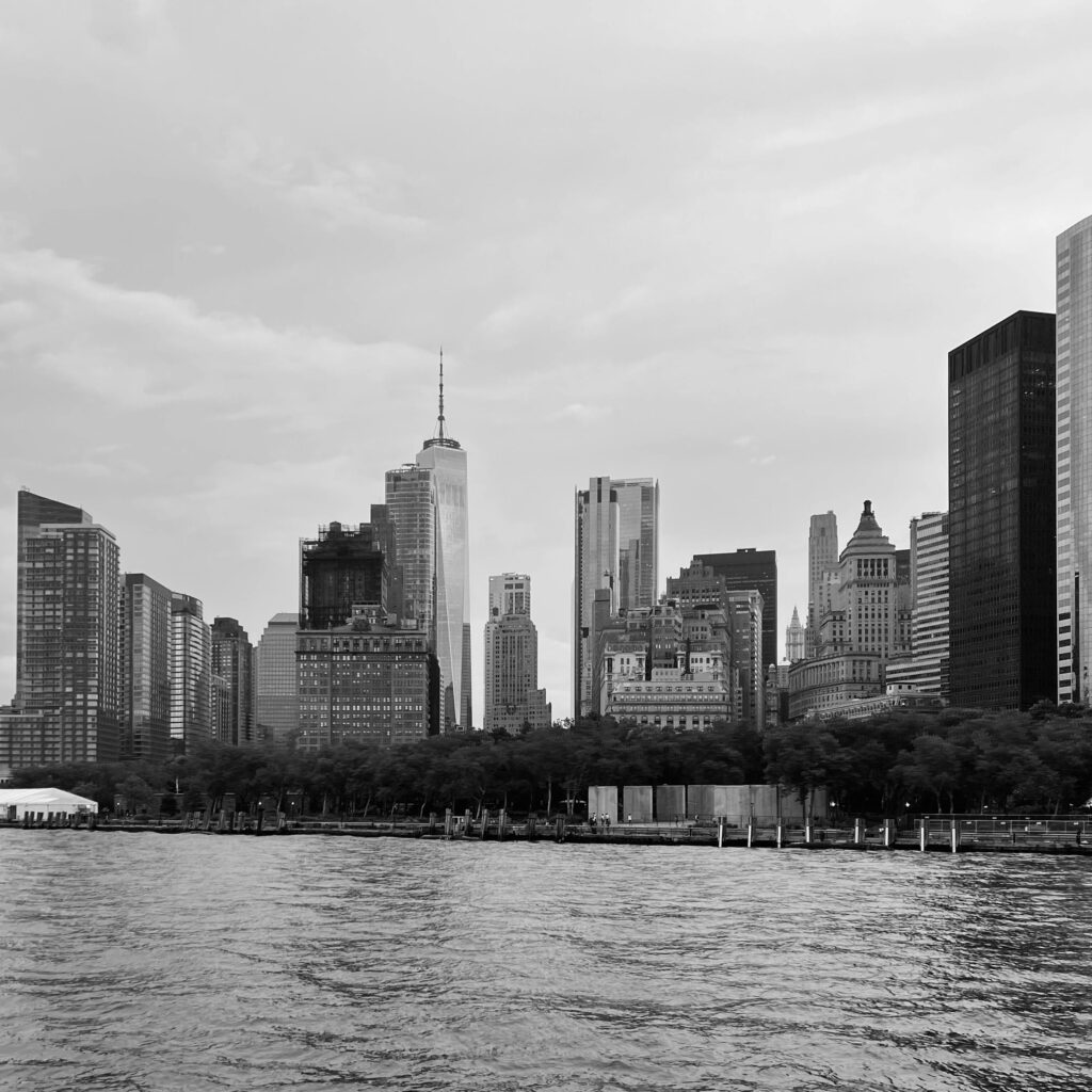 Monochrome view of Manhattan's iconic skyline with towering skyscrapers by the water.