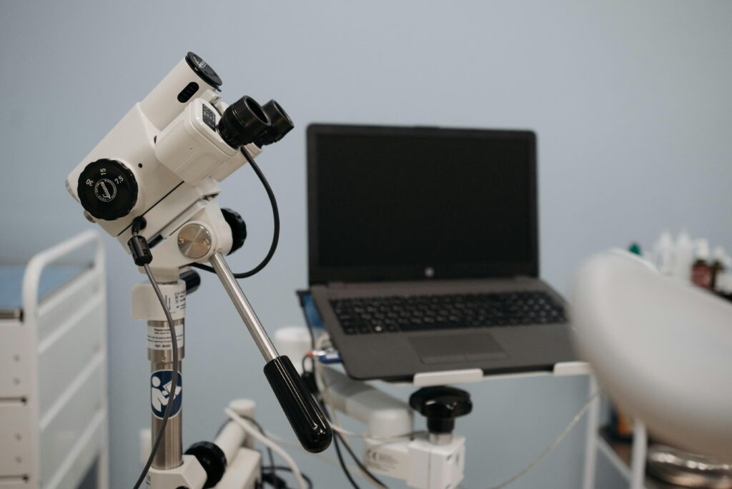 Close-up of ophthalmology machine and laptop in a medical examination room.