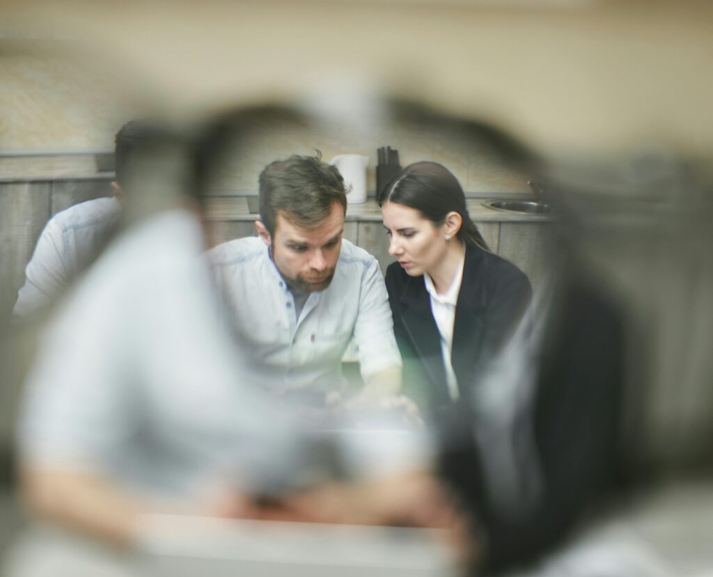 Two professionals engaged in a focused business discussion at a modern office setting.